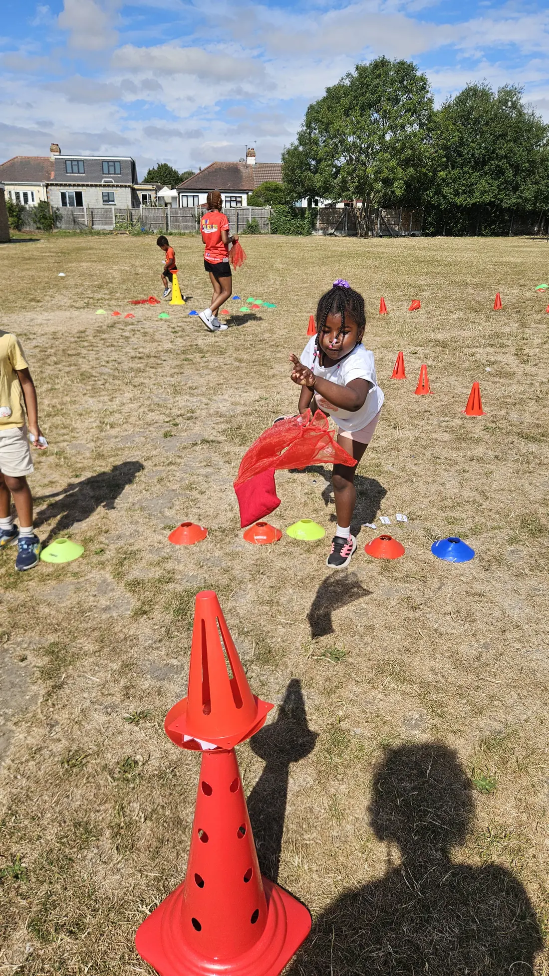 Child taking part in an outdoor throwing game at summer camp